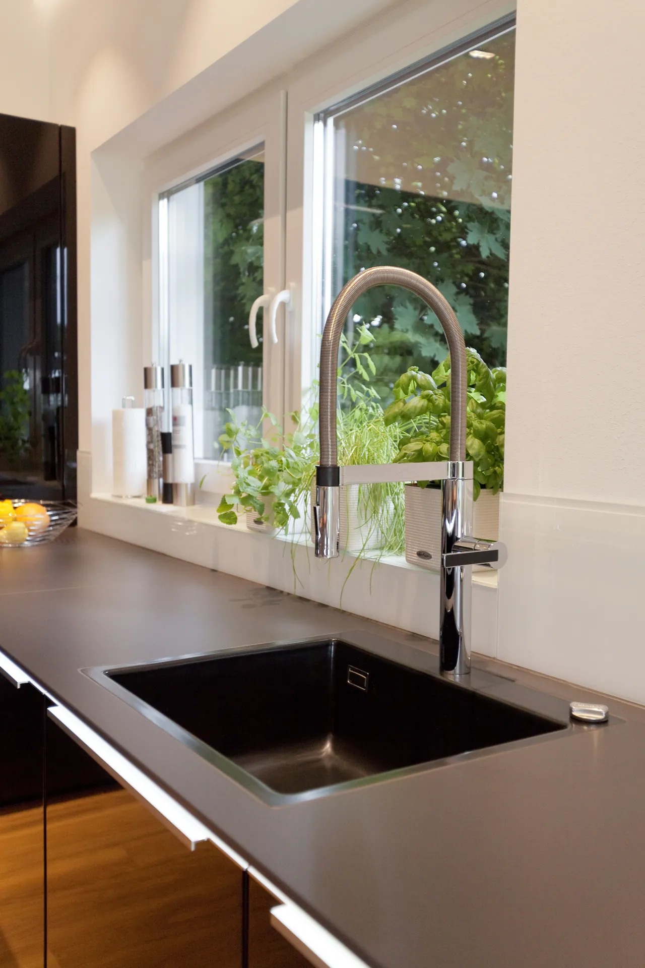 Designküche mit Kochinsel – Hochglanz Schwarz mit Naturstein-Arbeitsplatte