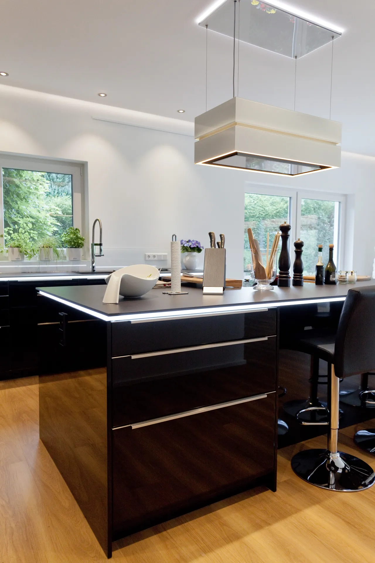 Designküche mit Kochinsel – Hochglanz Schwarz mit Naturstein-Arbeitsplatte