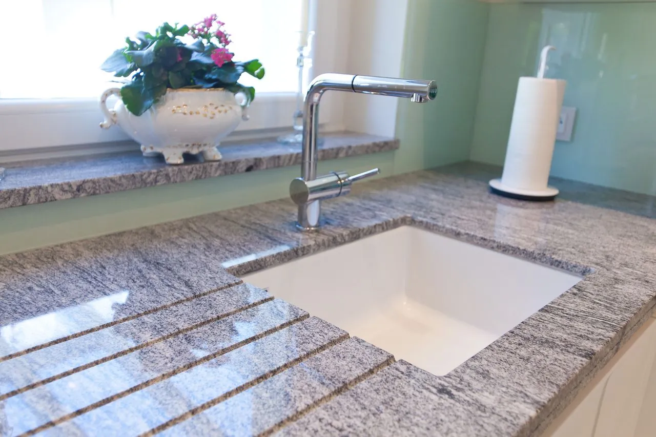 Grifflose Küche – Granit-Arbeitsplatte mit weißen Fronten