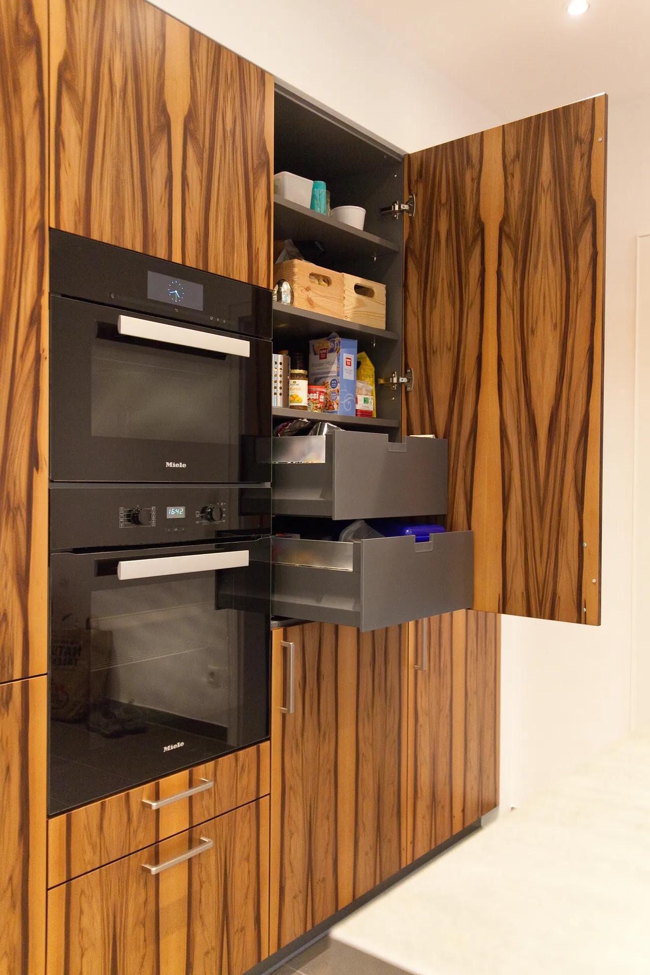 Designküche in U-Form – Naturstein und Holzfronten stilvoll kombiniert