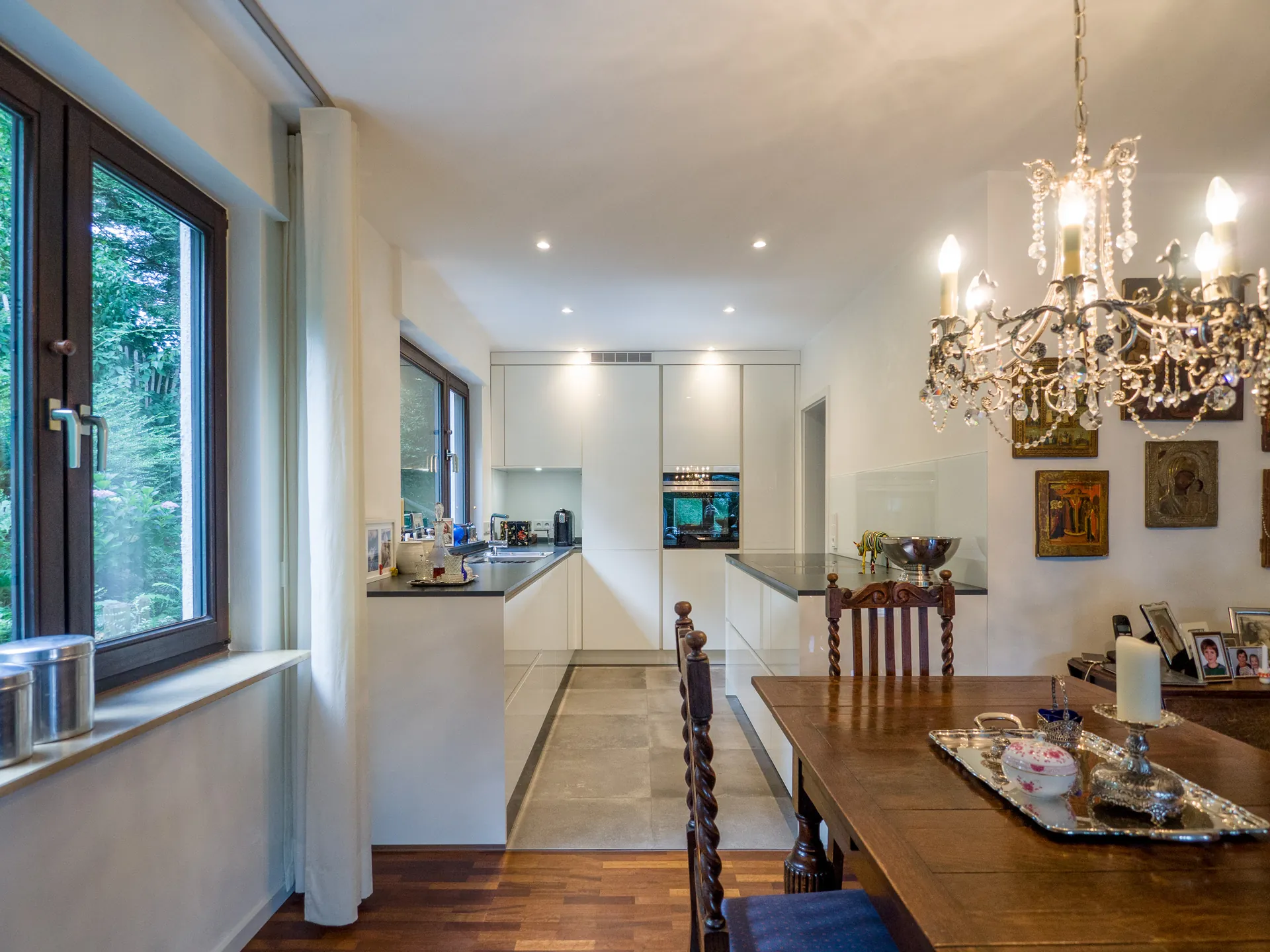 Designküche – Grifflose Hochglanz Küche in Weiß mit stilvoller Rückwand
