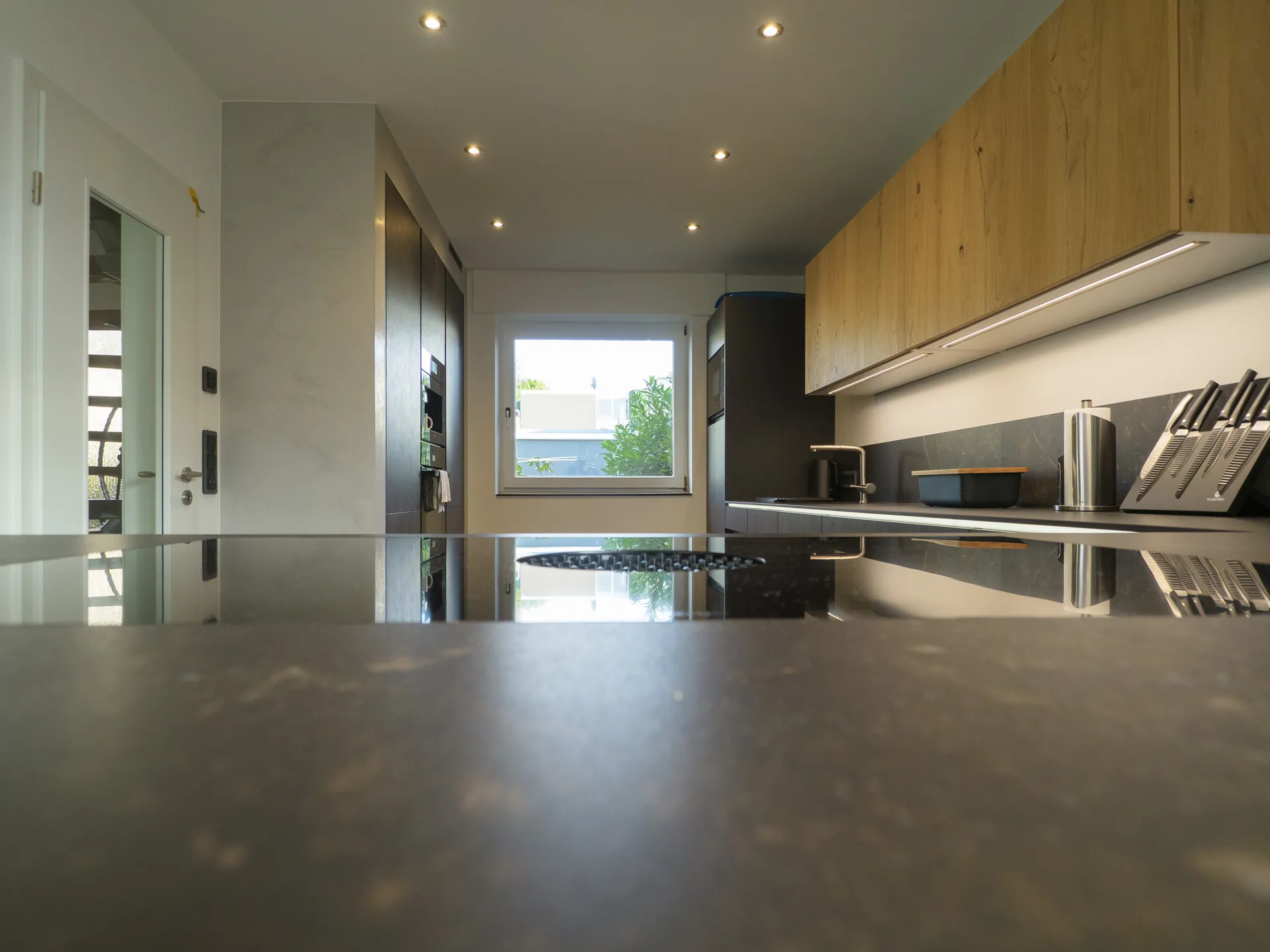 Designküche in Betonoptik – Grifflose Küche mit Hängeschränken