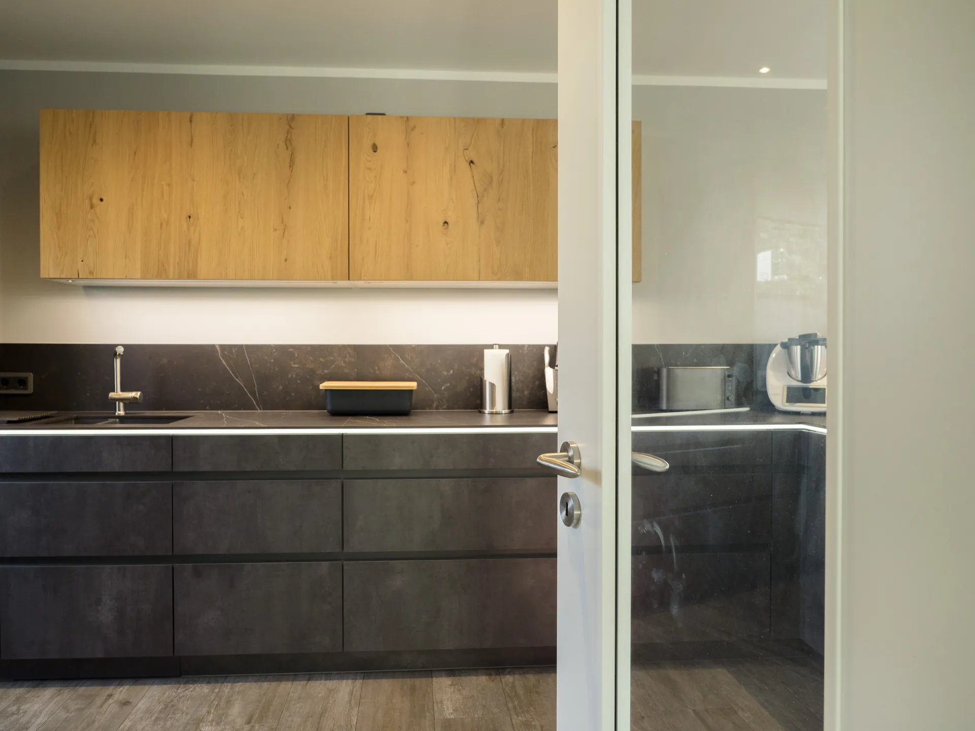 Designküche in Betonoptik – Grifflose Küche mit Hängeschränken