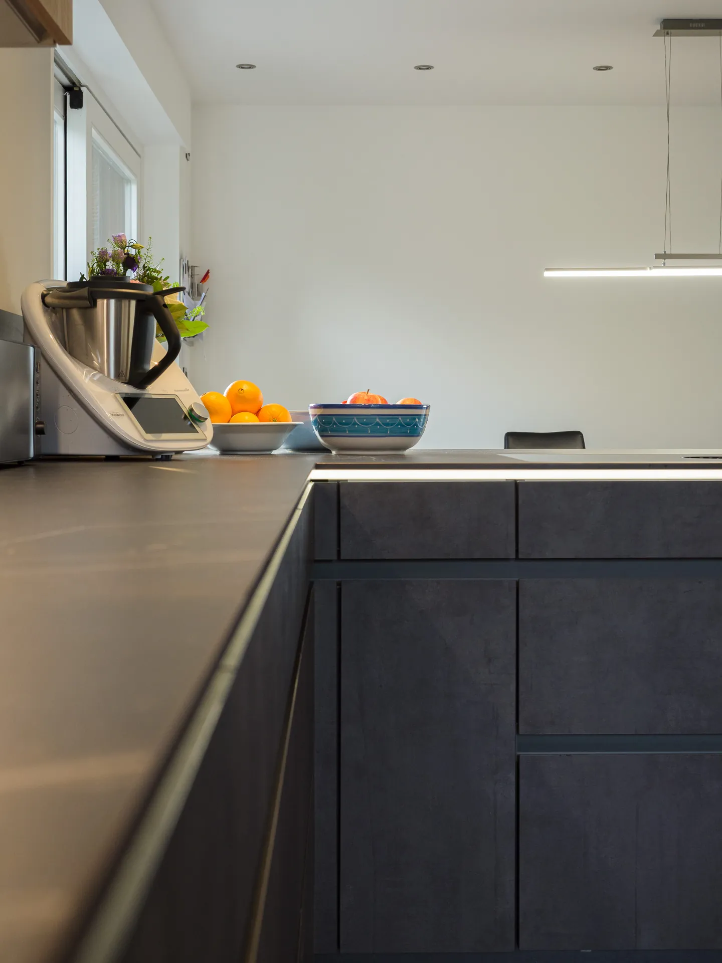 Designküche in Betonoptik – Grifflose Küche mit Hängeschränken
