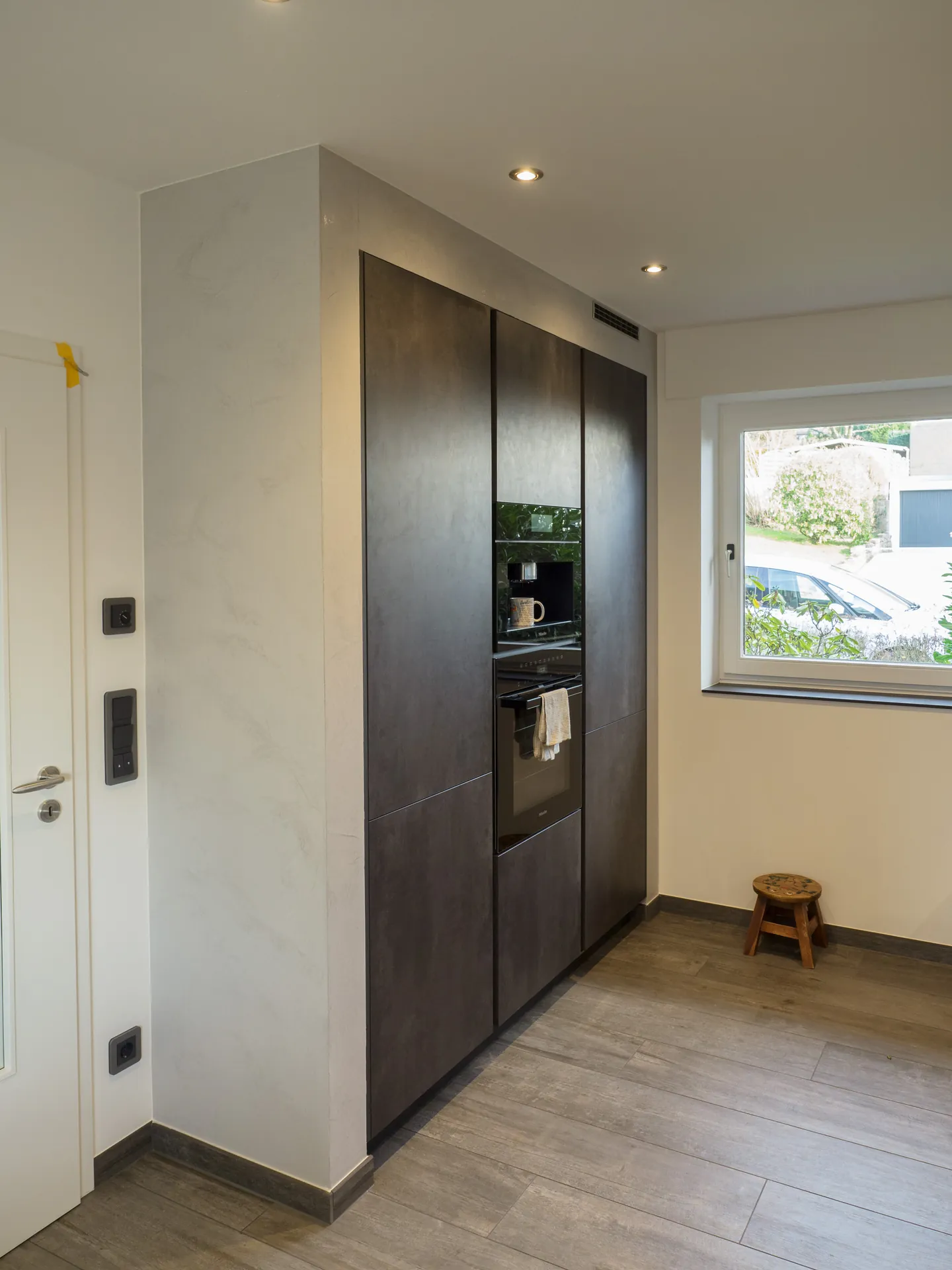 Designküche in Betonoptik – Grifflose Küche mit Hängeschränken