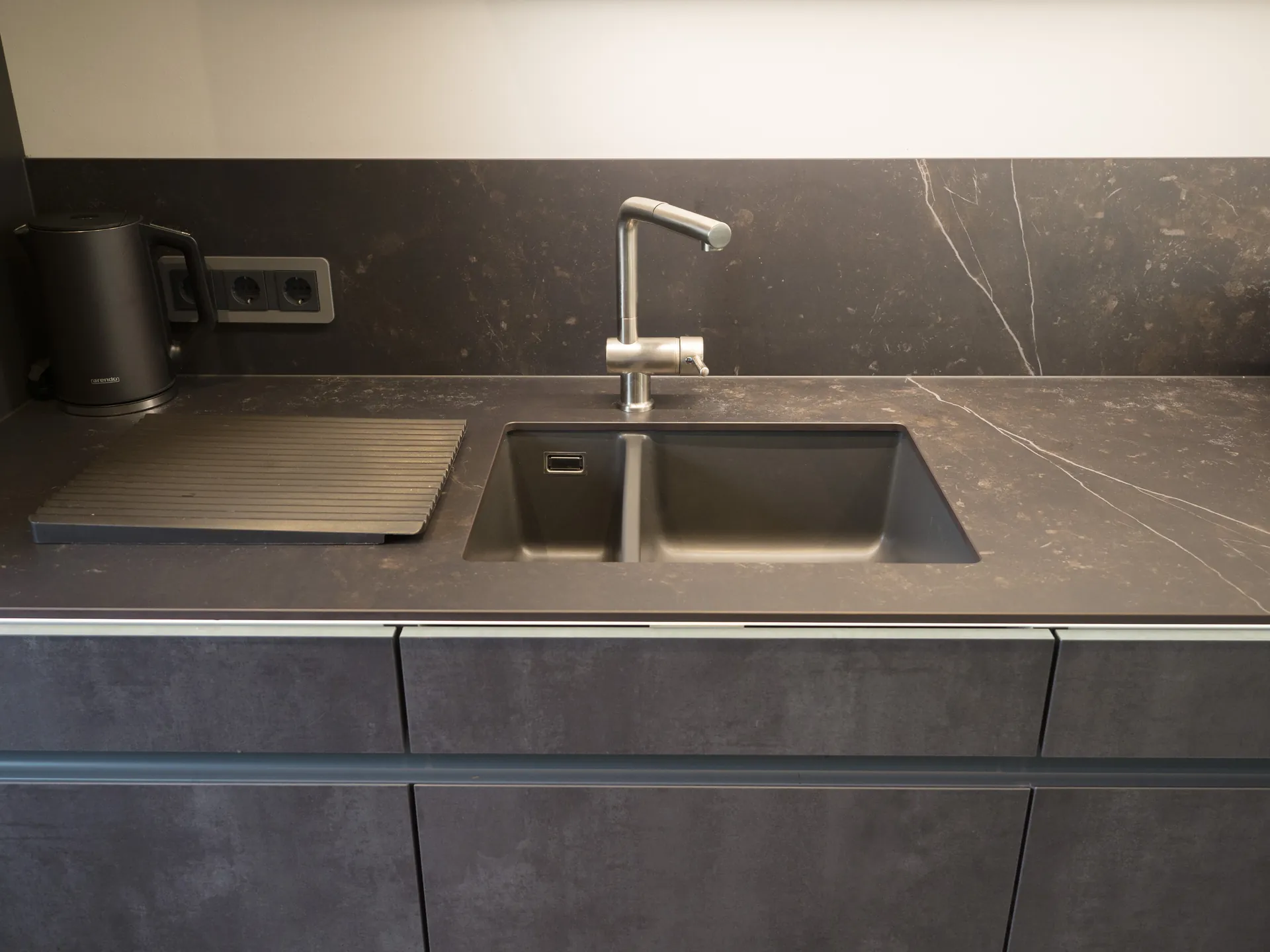 Designküche in Betonoptik – Grifflose Küche mit Hängeschränken