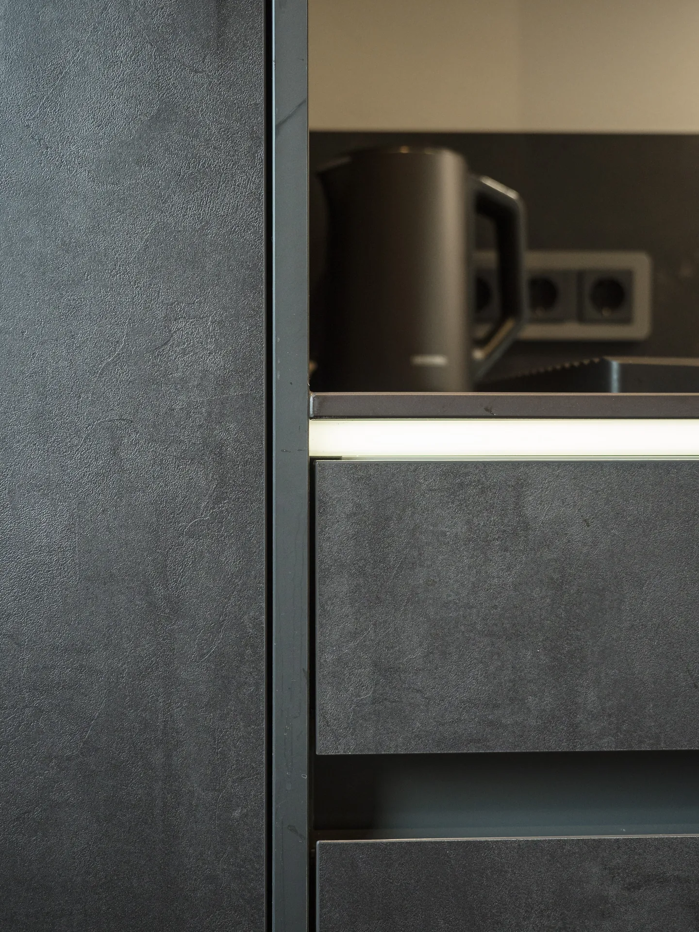 Designküche in Betonoptik – Grifflose Küche mit Hängeschränken