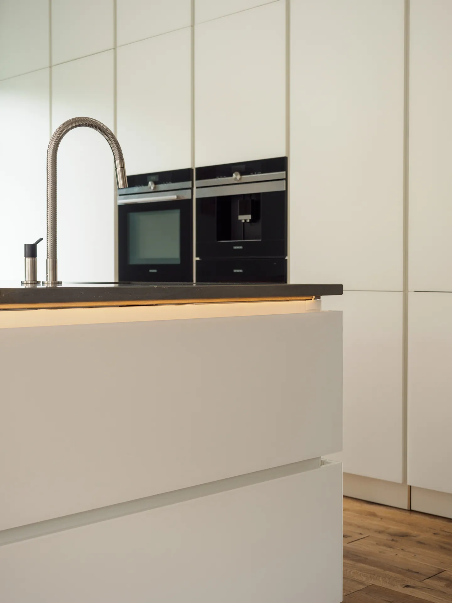 Designküche mit Kochinsel – Grifflose Wohnküche mit großer Insel