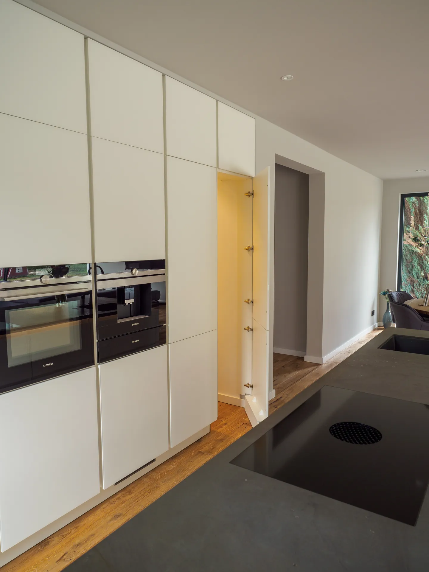 Designküche mit Kochinsel – Grifflose Wohnküche mit großer Insel
