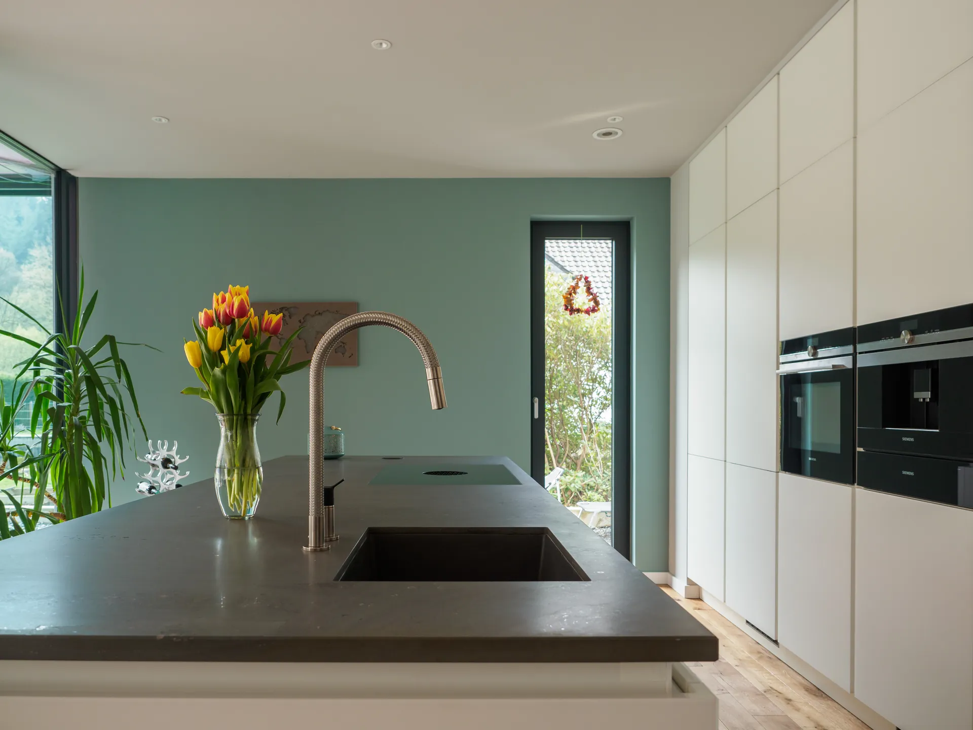 Designküche mit Kochinsel – Grifflose Wohnküche mit großer Insel