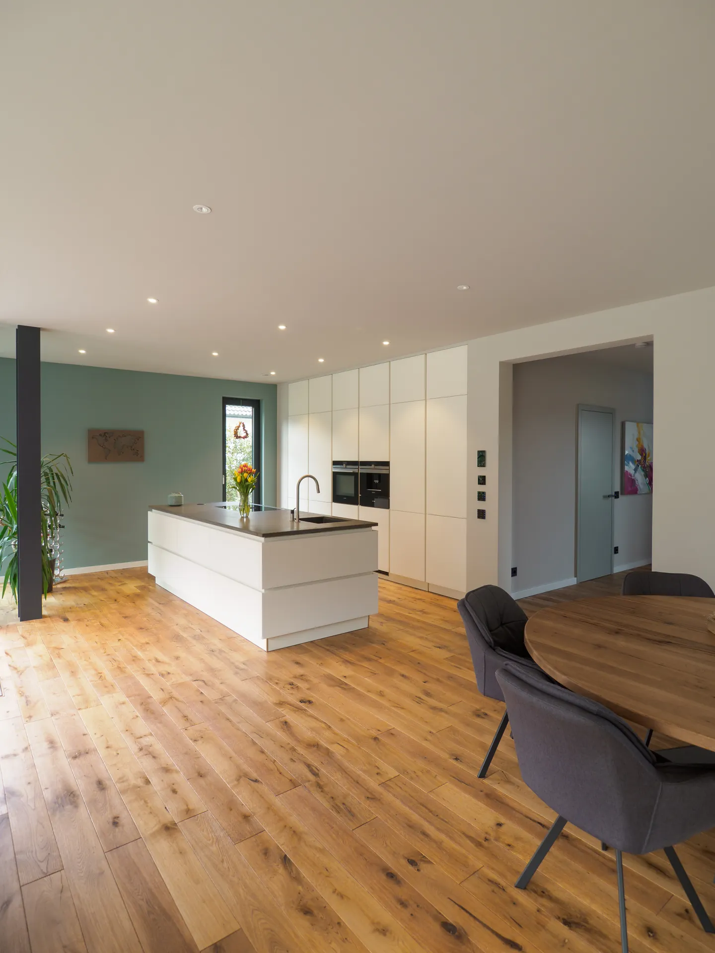 Designküche mit Kochinsel – Grifflose Wohnküche mit großer Insel