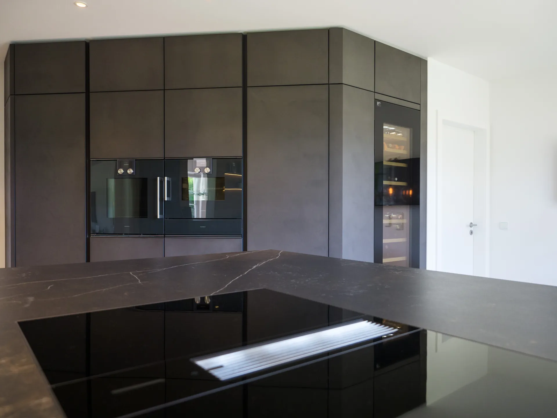 Designküche in Betonoptik – Grifflose Wohnküche mit Echtbetonfront