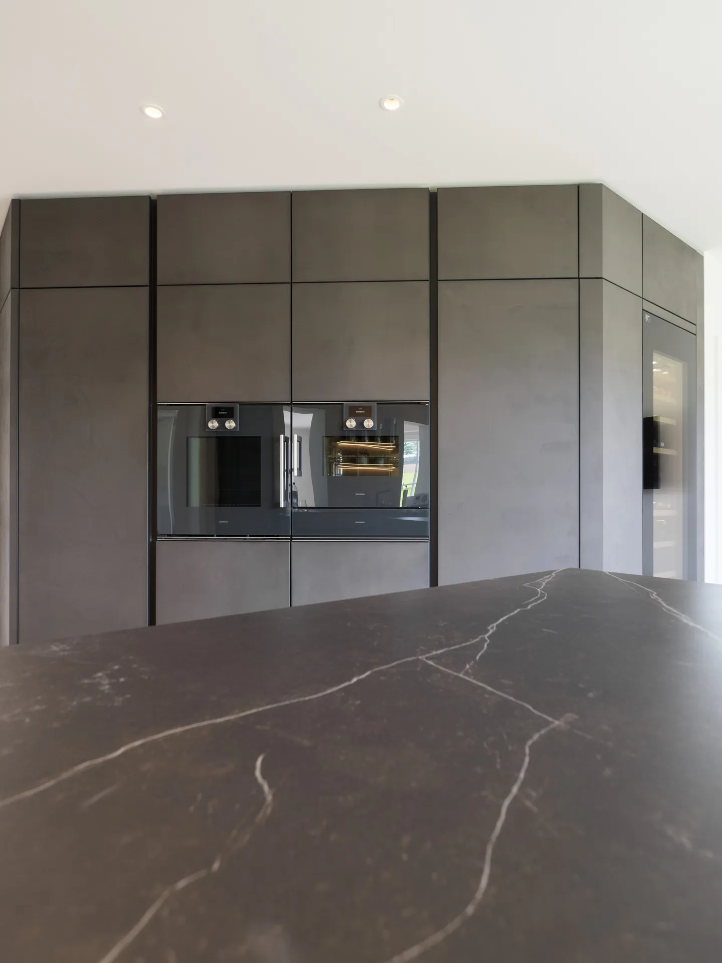 Designküche in Betonoptik – Grifflose Wohnküche mit Echtbetonfront