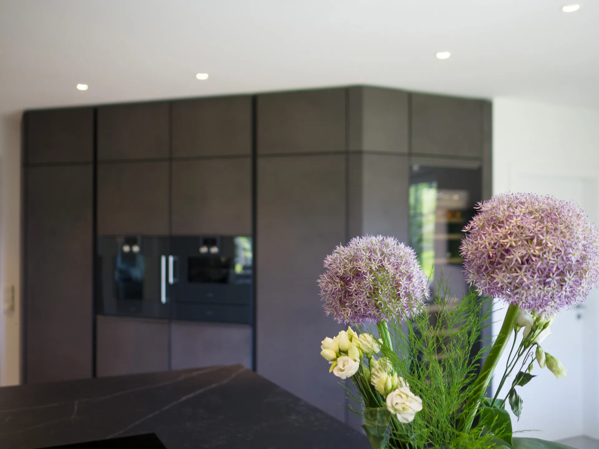 Designküche in Betonoptik – Grifflose Wohnküche mit Echtbetonfront