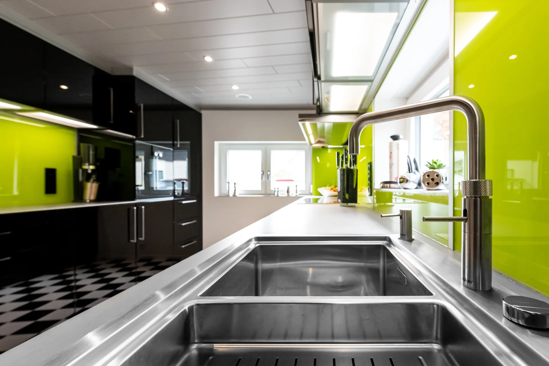 Designküche in Schwarz – Hochglanz Küche mit Naturstein-Arbeitsplatte