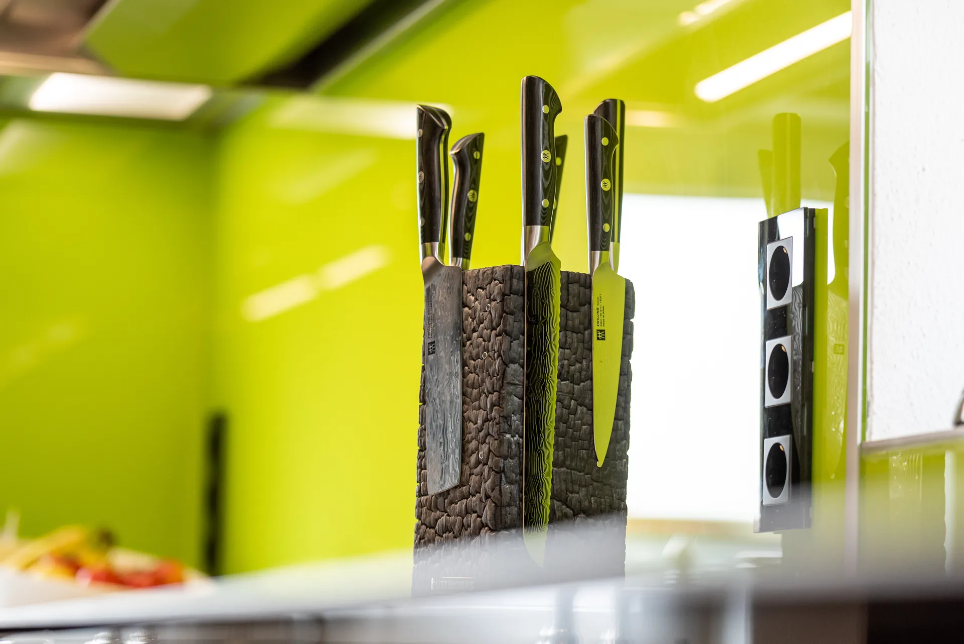 Designküche in Schwarz – Hochglanz Küche mit Naturstein-Arbeitsplatte