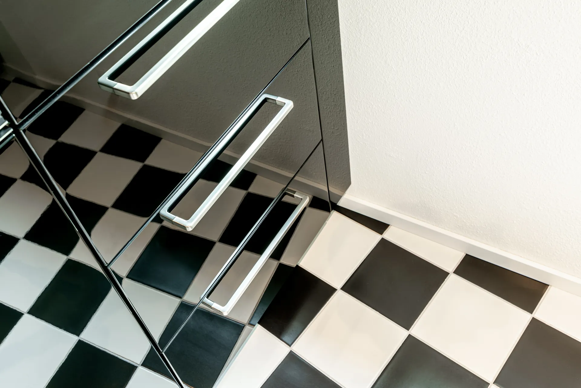 Designküche in Schwarz – Hochglanz Küche mit Naturstein-Arbeitsplatte