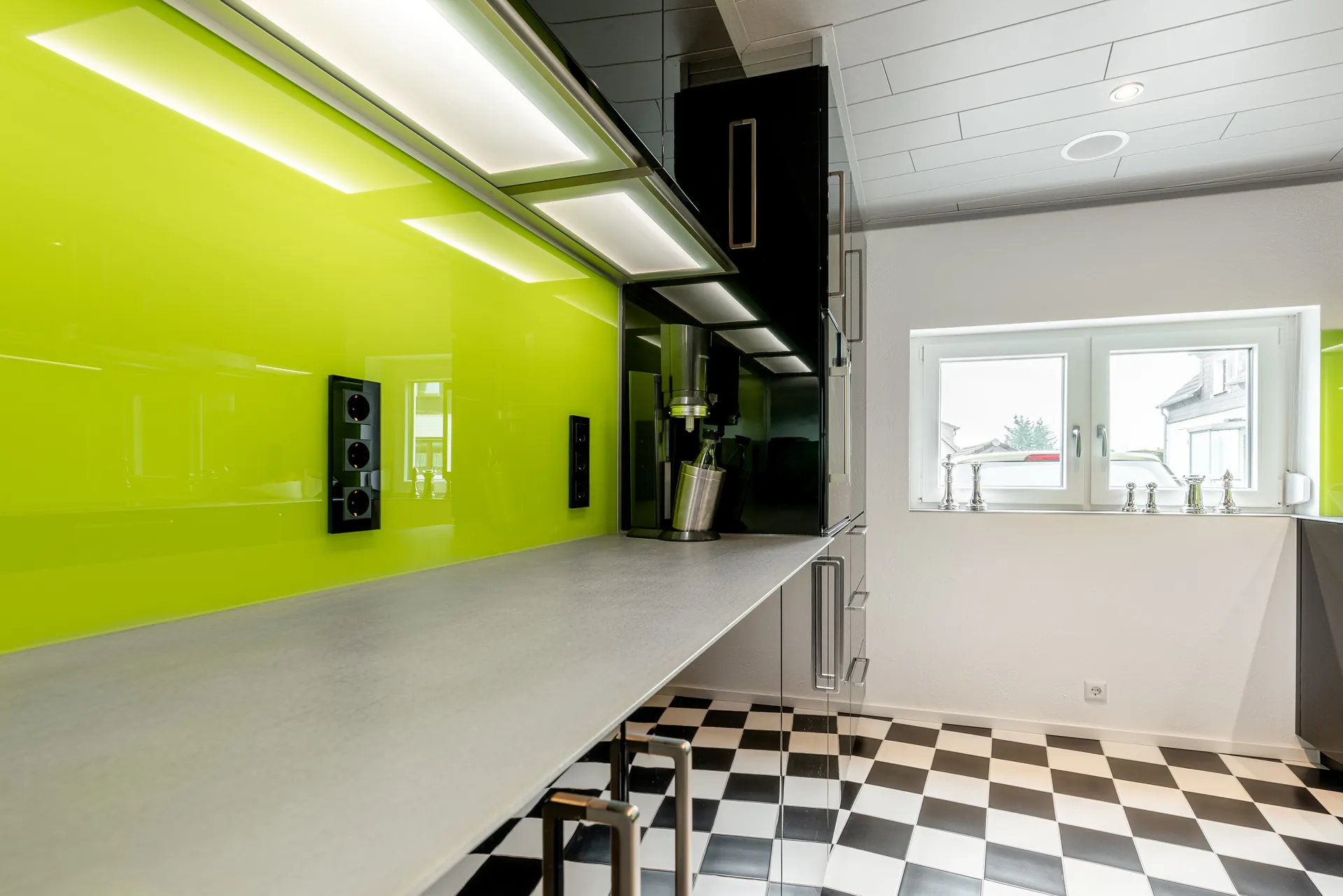 Designküche in Schwarz – Hochglanz Küche mit Naturstein-Arbeitsplatte