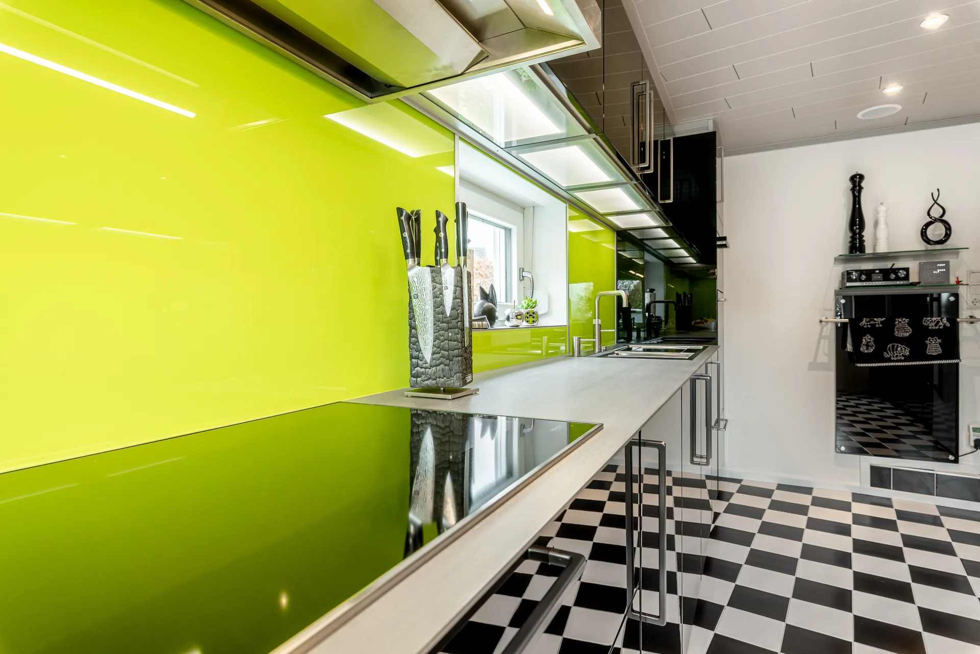 Designküche in Schwarz – Hochglanz Küche mit Naturstein-Arbeitsplatte