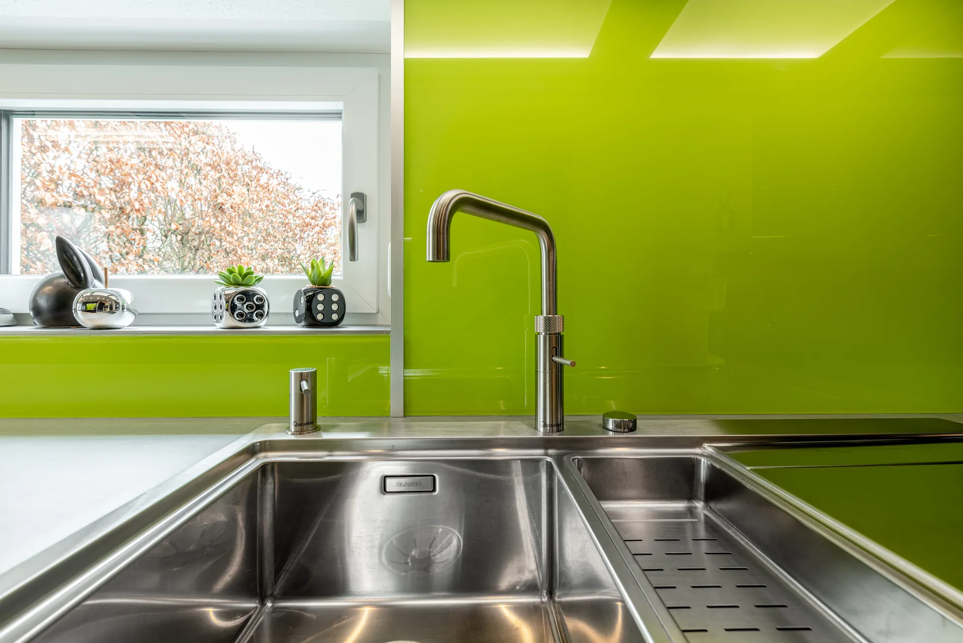 Designküche in Schwarz – Hochglanz Küche mit Naturstein-Arbeitsplatte