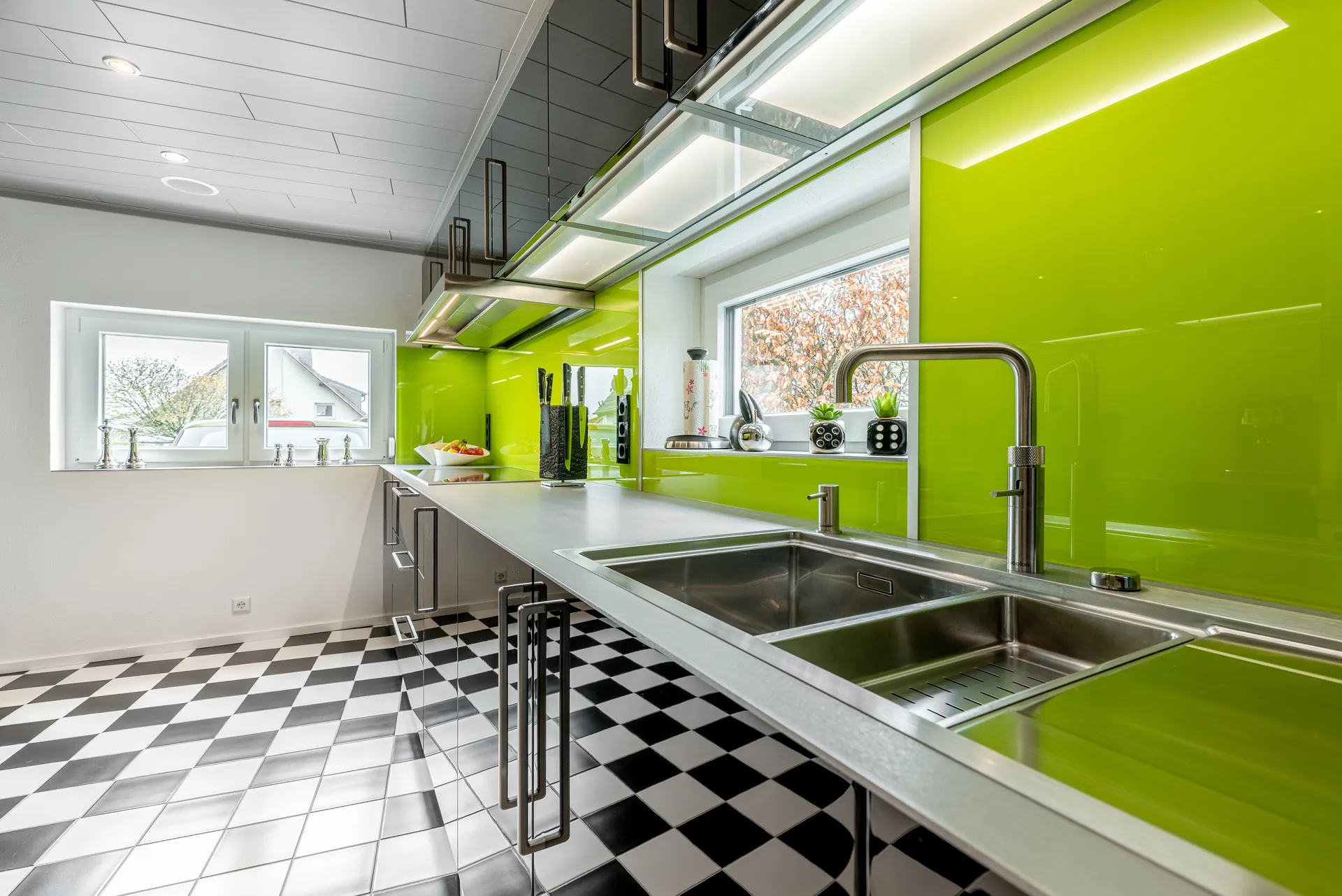 Designküche in Schwarz – Hochglanz Küche mit Naturstein-Arbeitsplatte