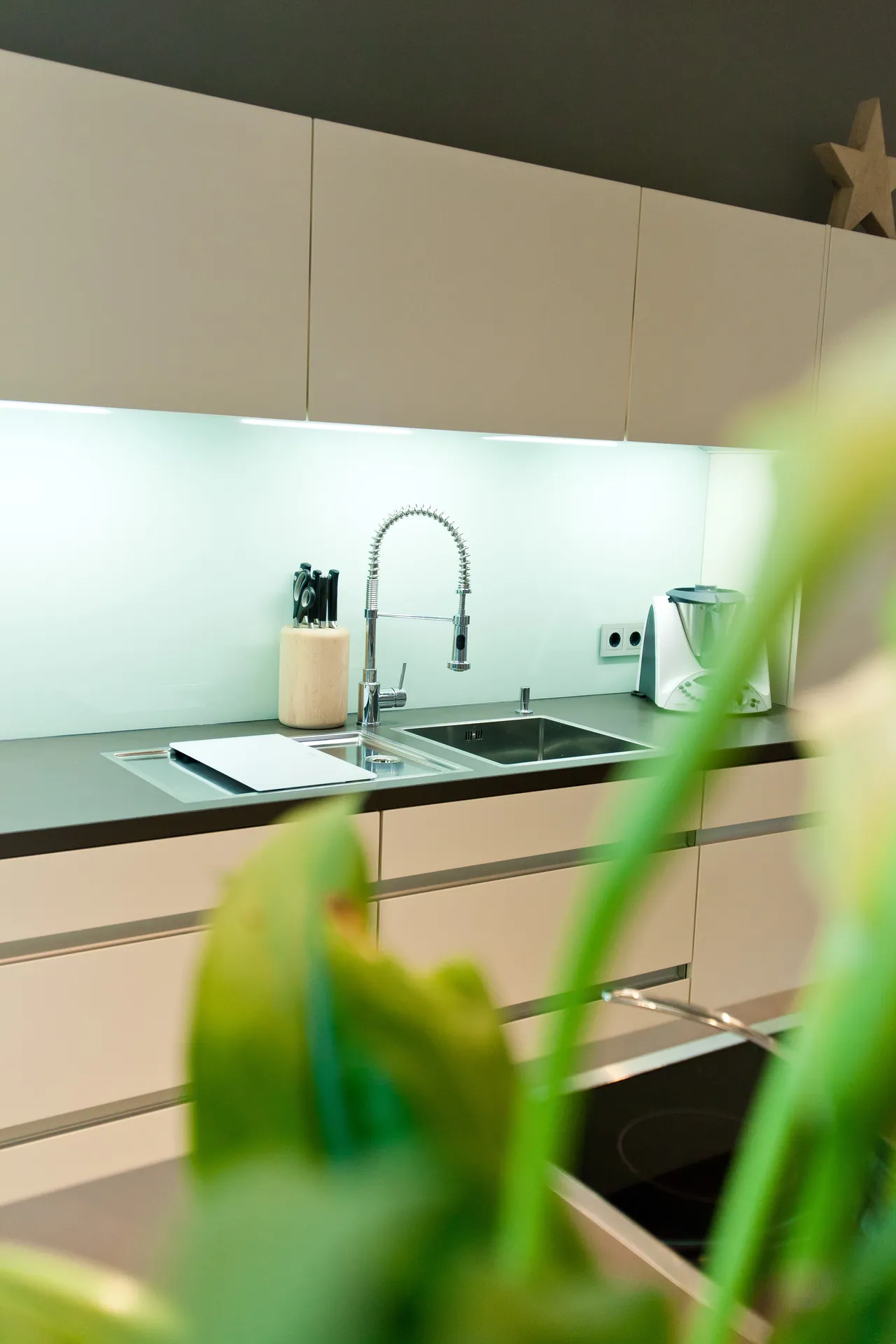 Grifflose Designküche – Weiße Küche mit Grauwacke und Gaggenau Geräten