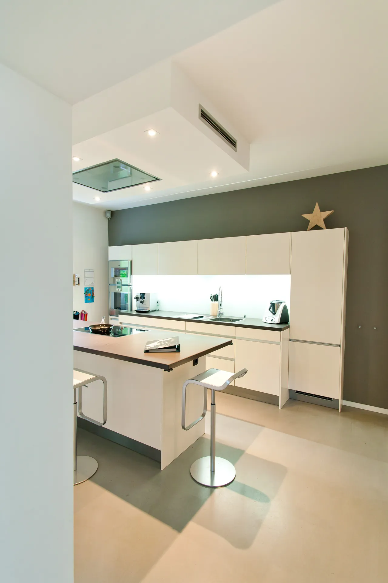 Grifflose Designküche – Weiße Küche mit Grauwacke und Gaggenau Geräten