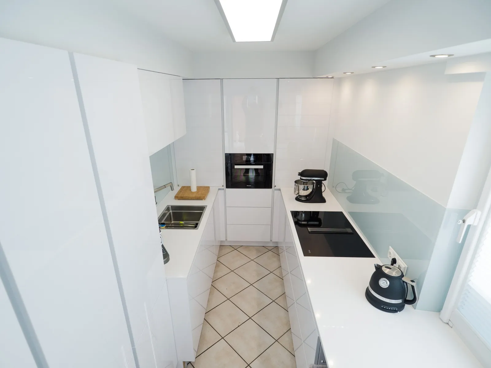 Grifflose U-Küche – Polarweiß Hochglanz mit Silestone-Arbeitsplatte