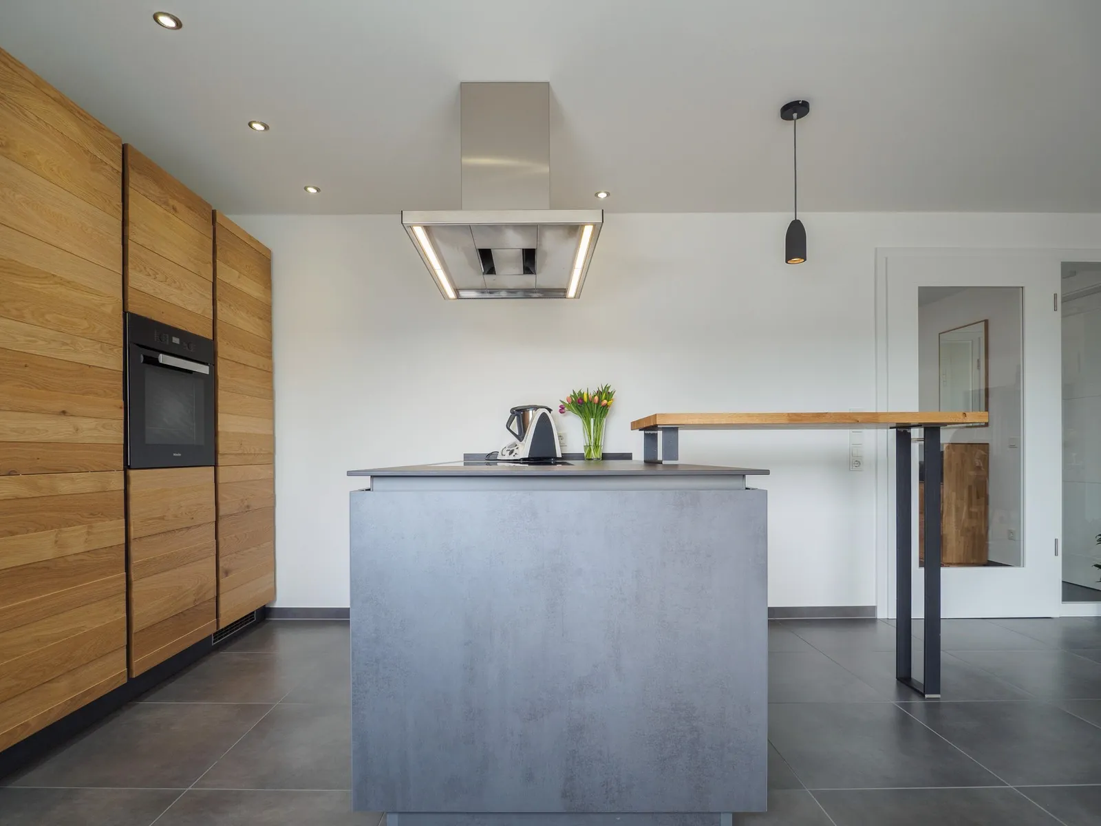 Grifflose Designküche mit Insel – Betonoptik mit Eiche und Dekton