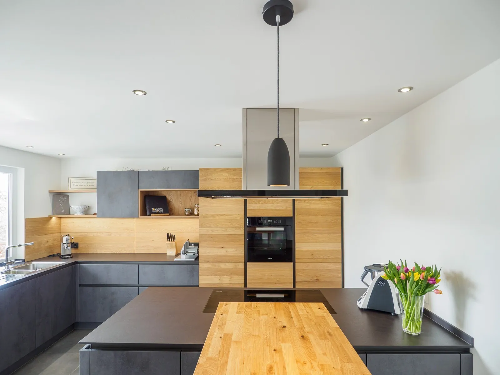 Grifflose Designküche mit Insel – Betonoptik mit Eiche und Dekton
