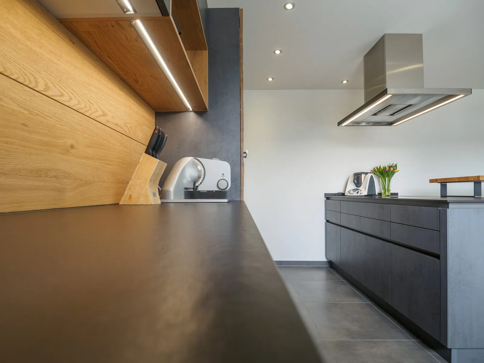 Grifflose Designküche mit Insel – Betonoptik mit Eiche und Dekton