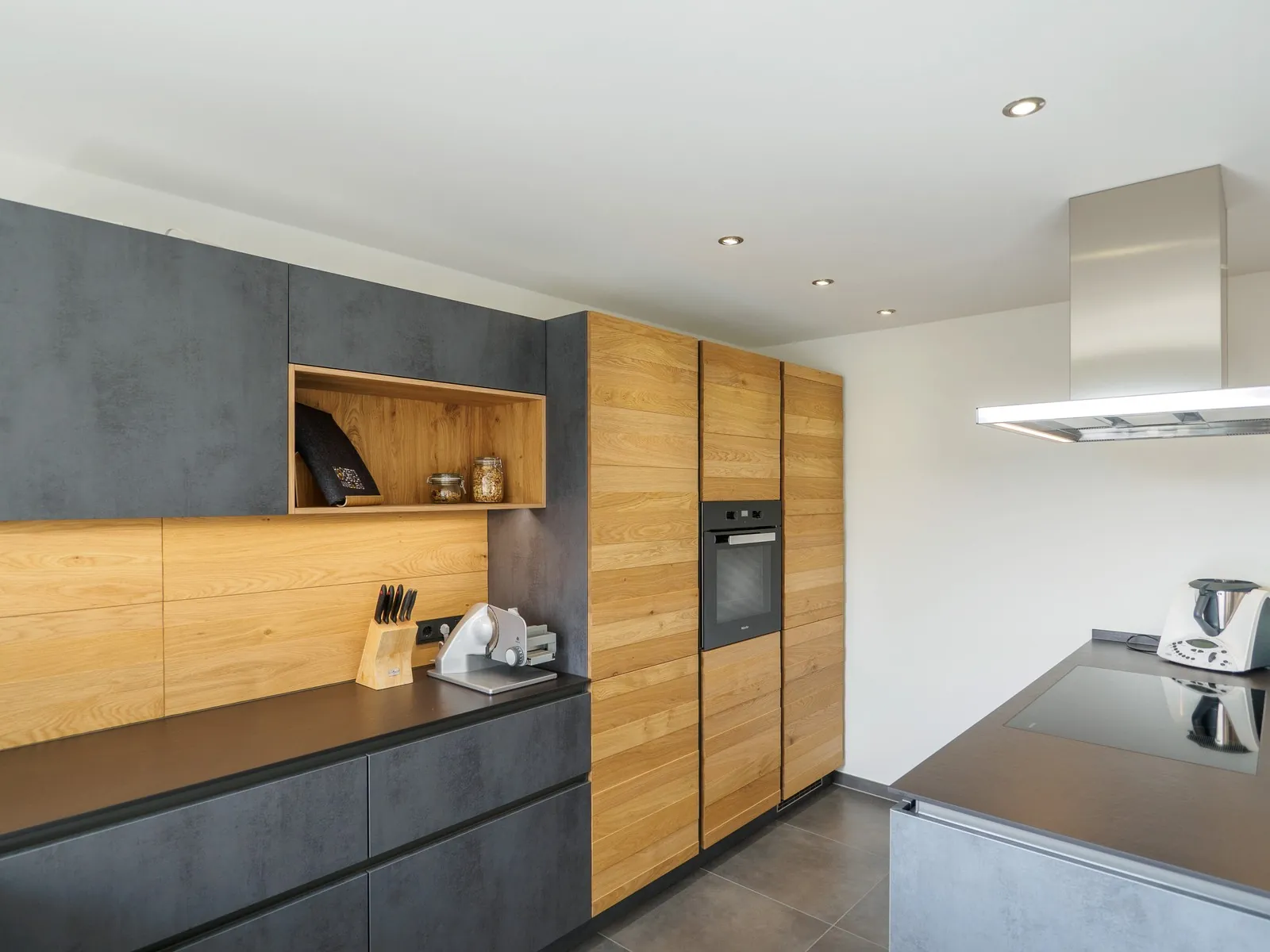 Grifflose Designküche mit Insel – Betonoptik mit Eiche und Dekton