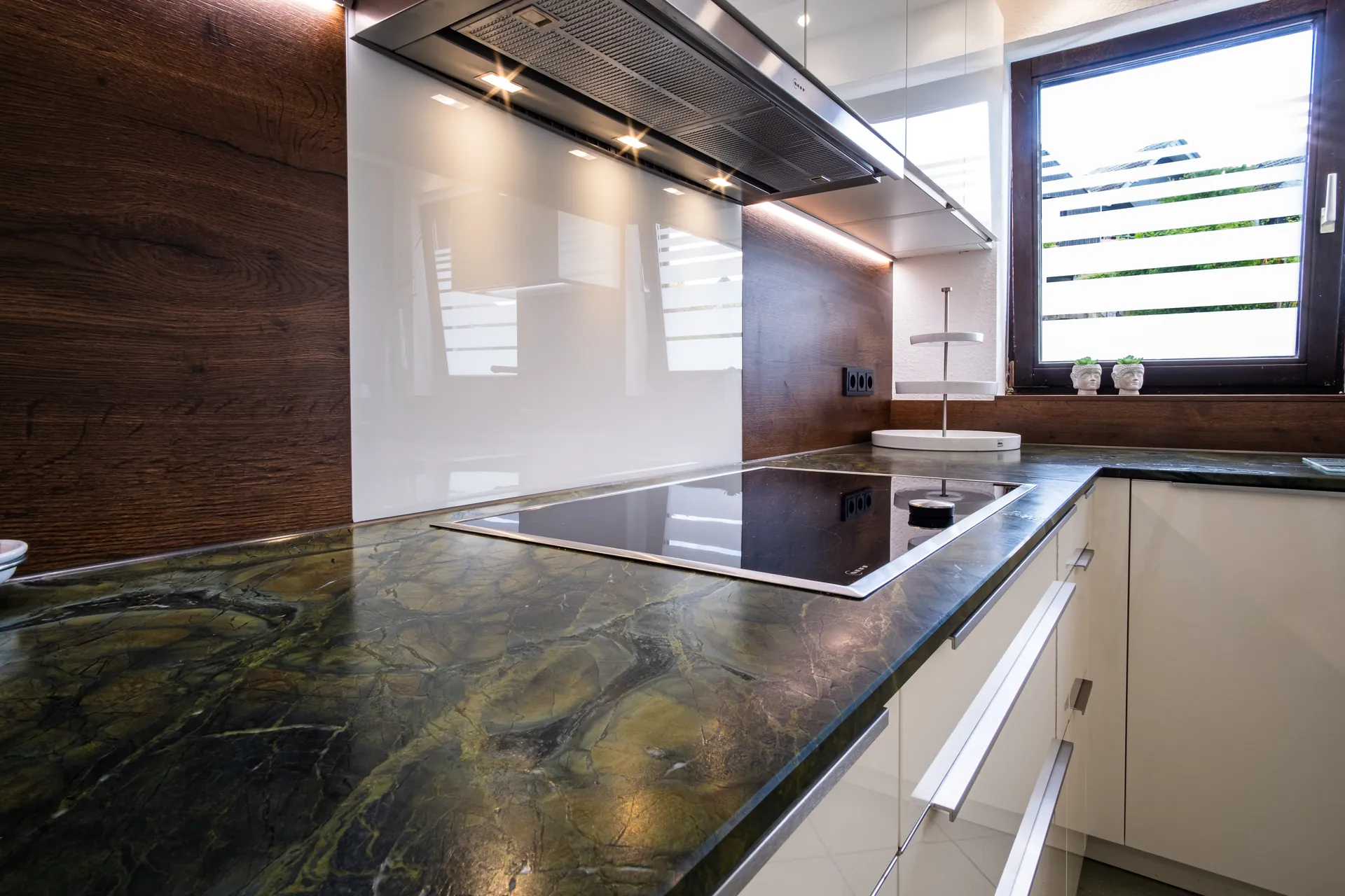 Designküche in U-Form – Naturstein und Holz mit NEFF Geräten