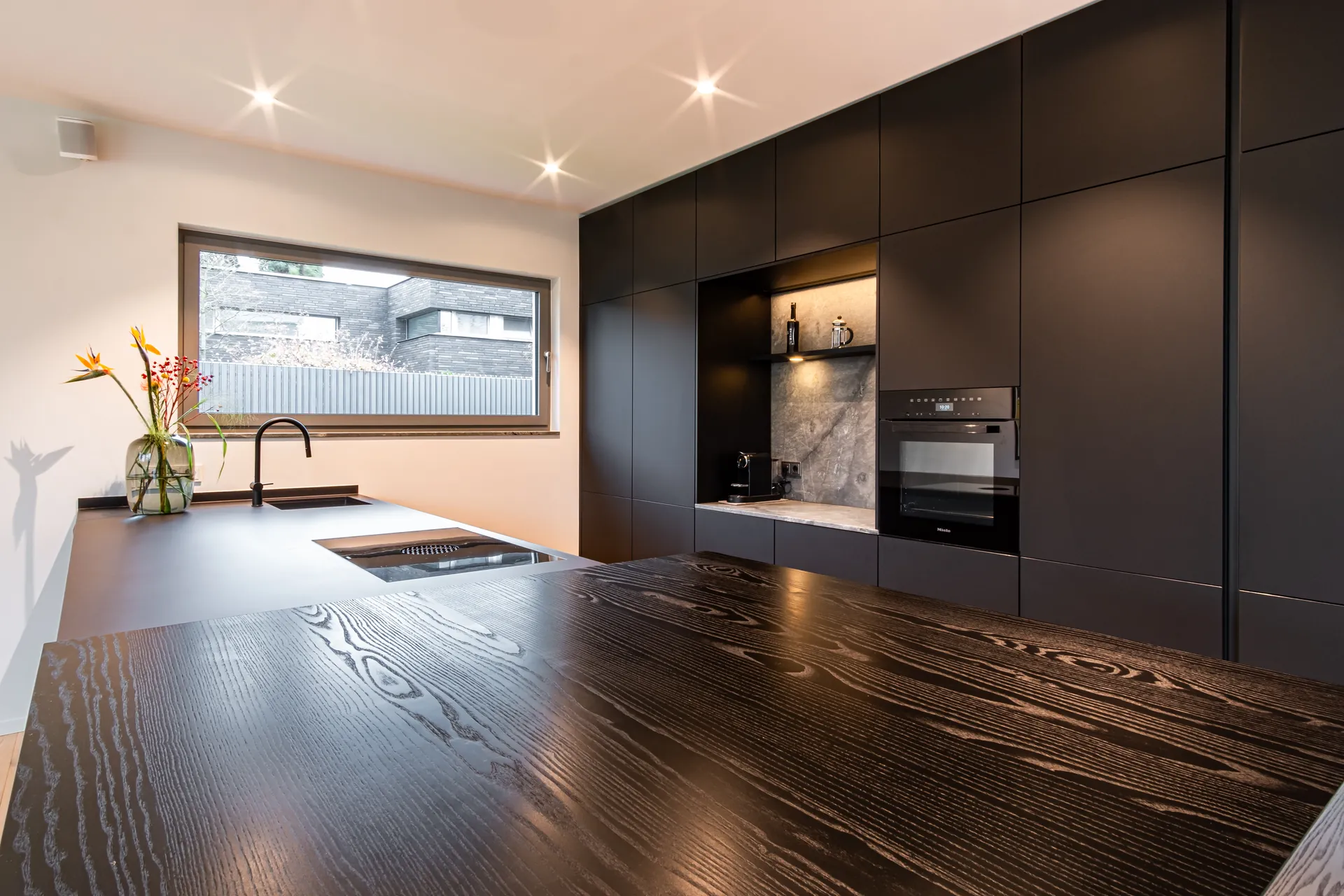 Designküche mit Kochinsel – Schreinerküche mit Holz, Keramik und Naturstein