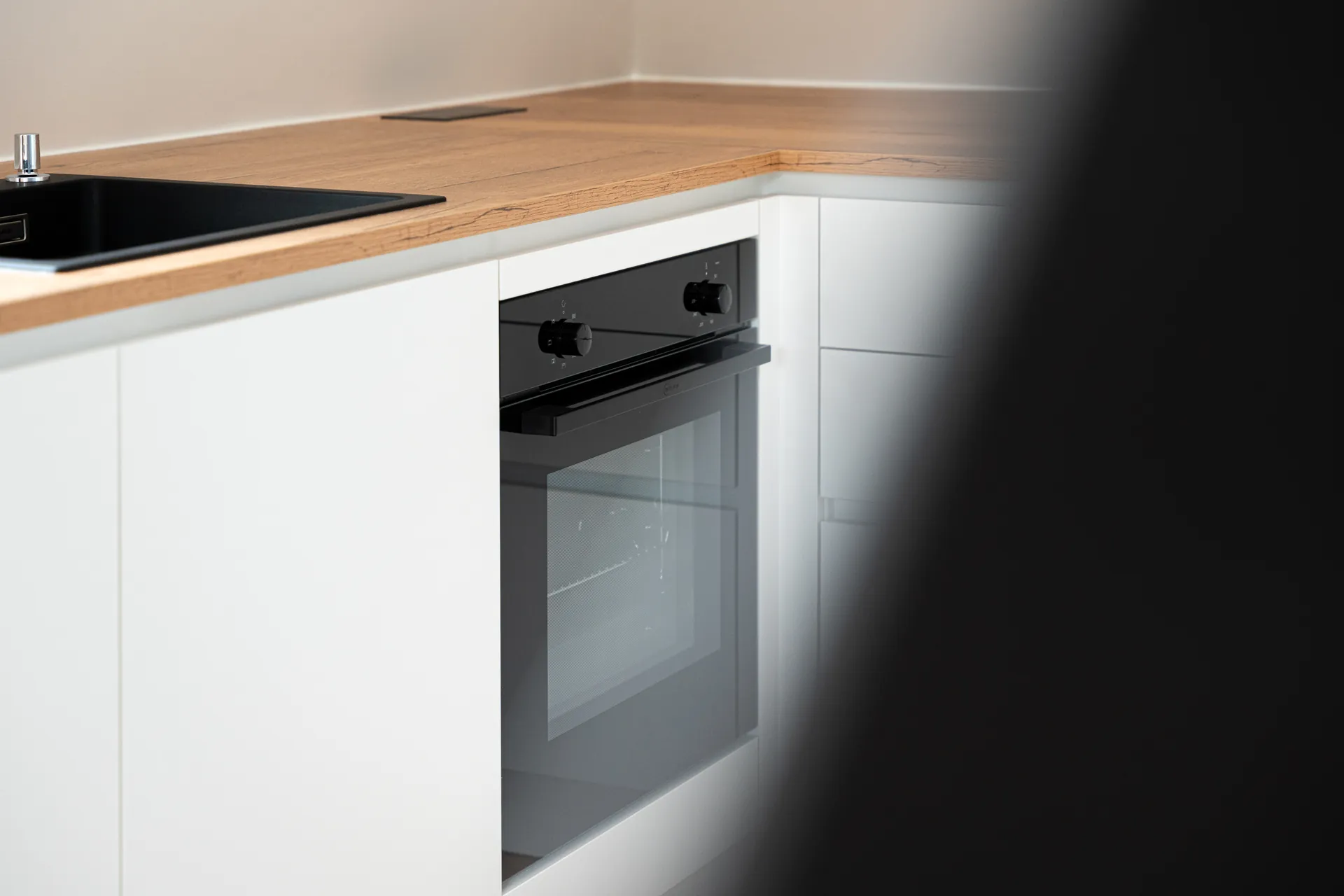 Grifflose Schreinerküche – L-Form mit Holz und Keramik