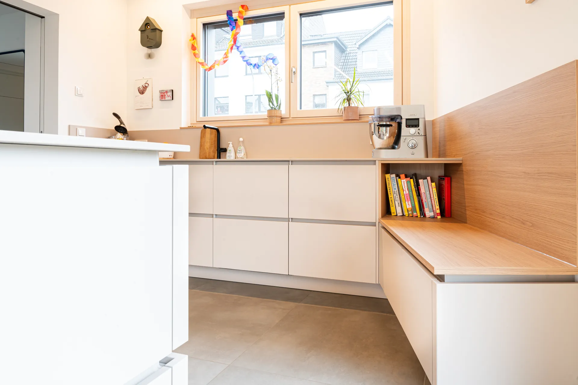 Grifflose Designküche mit Insel – L-Form mit Holz und Keramik