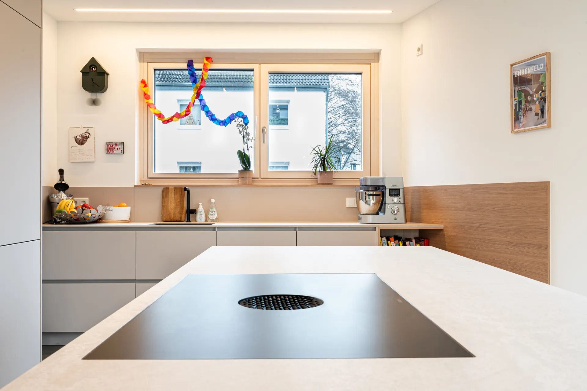 Grifflose Designküche mit Insel – L-Form mit Holz und Keramik
