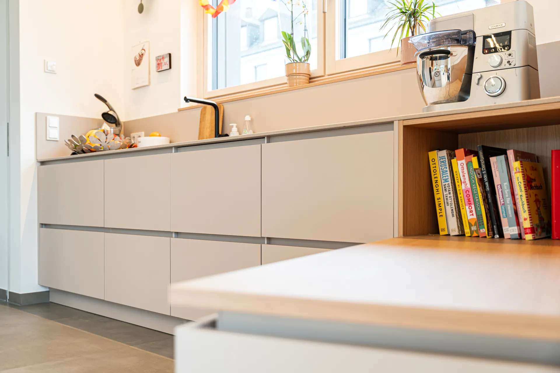 Grifflose Designküche mit Insel – L-Form mit Holz und Keramik
