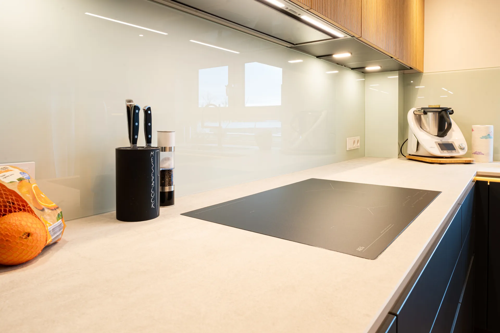 Grifflose Designküche in L-Form – Keramik und Holz mit Siemens