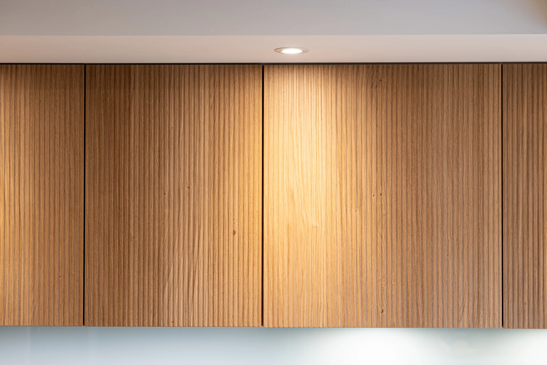 Grifflose Designküche in L-Form – Keramik und Holz mit Siemens