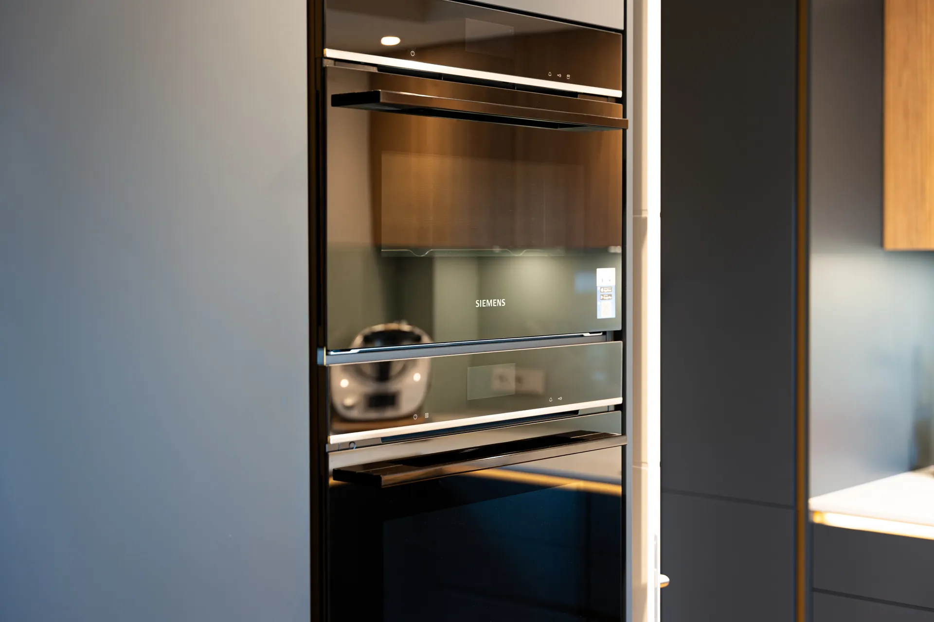 Grifflose Designküche in L-Form – Keramik und Holz mit Siemens