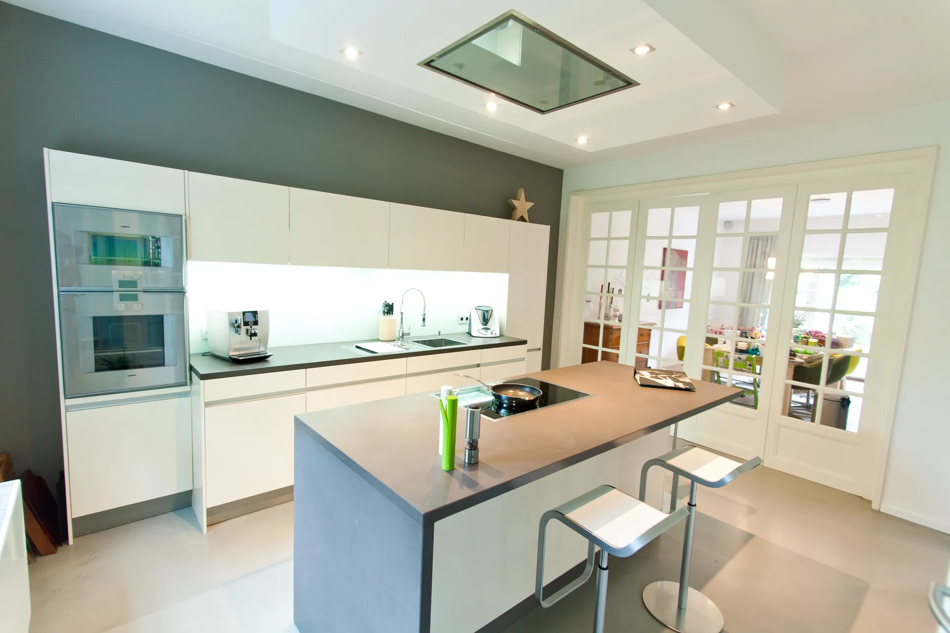 Grifflose Designküche – Weiße Küche mit Grauwacke und Gaggenau Geräten