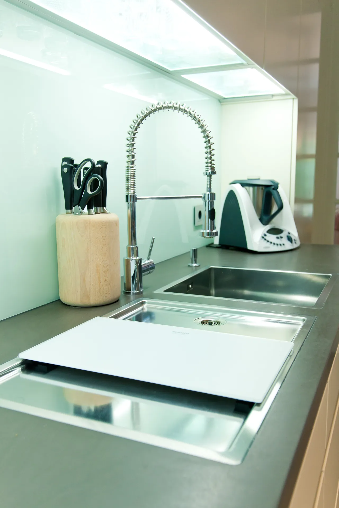 Grifflose Designküche – Weiße Küche mit Grauwacke und Gaggenau Geräten