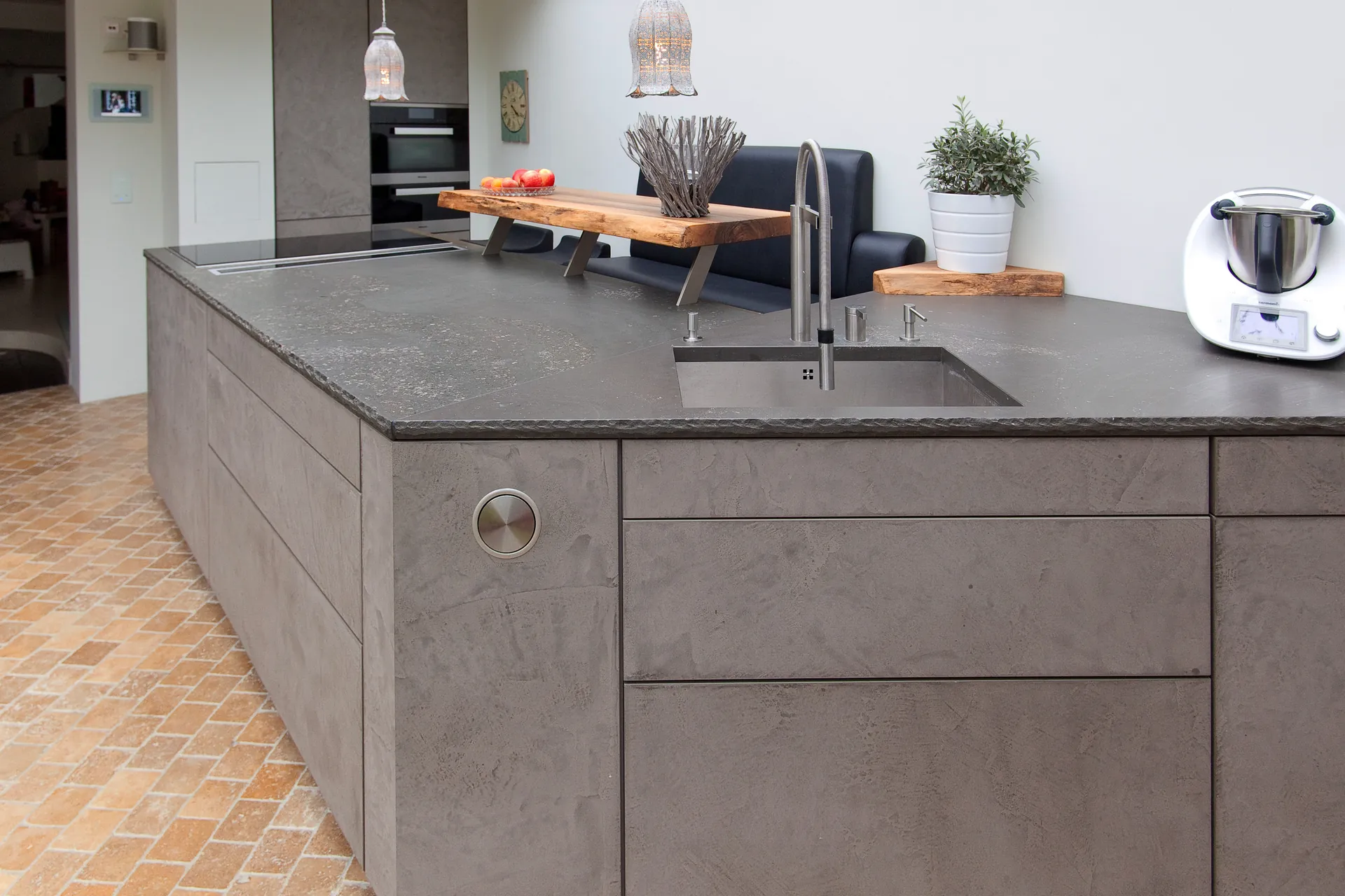 Designküche in Betonoptik – Grauwacke-Arbeitsplatte und markante Fronten