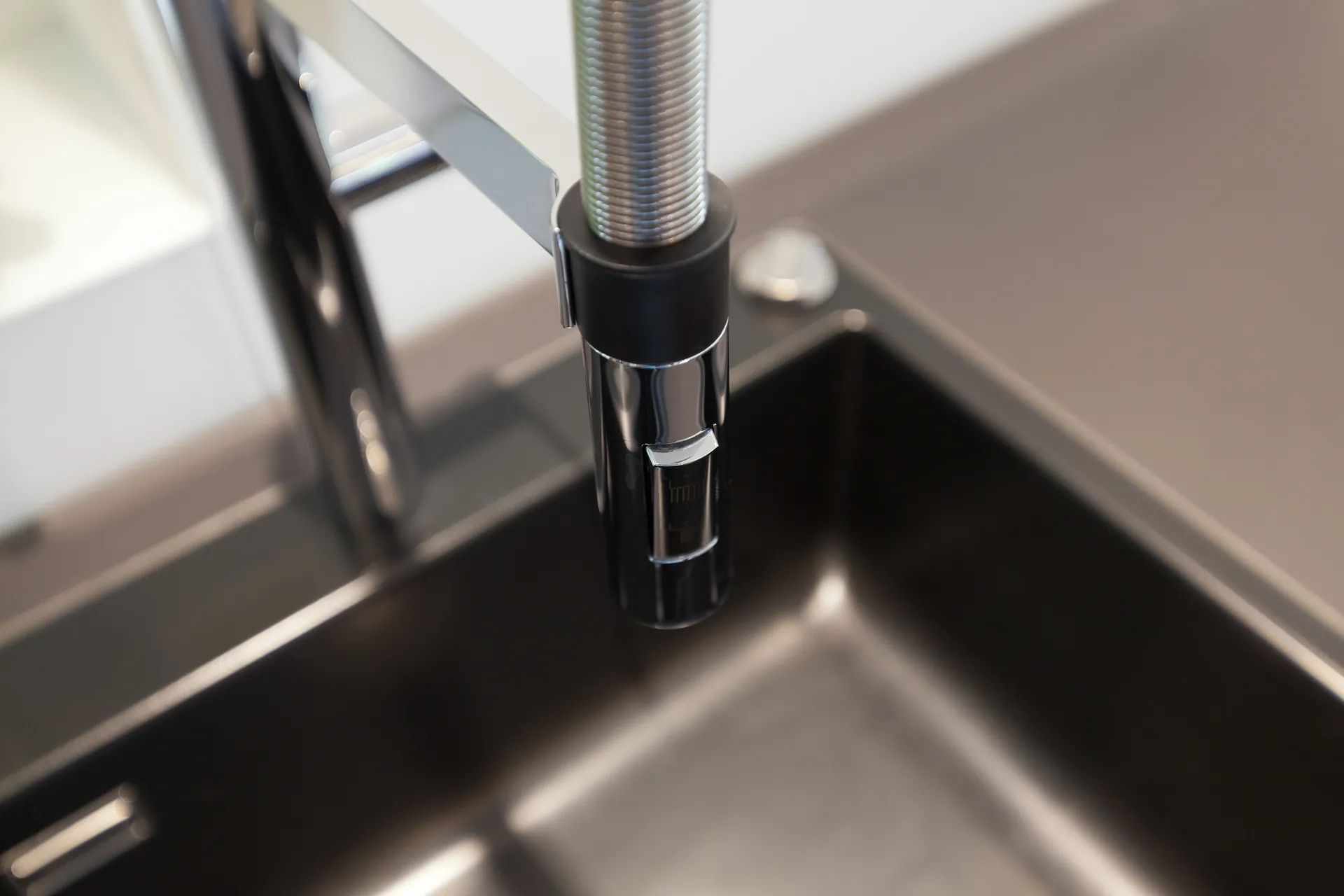 Designküche mit Kochinsel – Hochglanz Schwarz mit Naturstein-Arbeitsplatte
