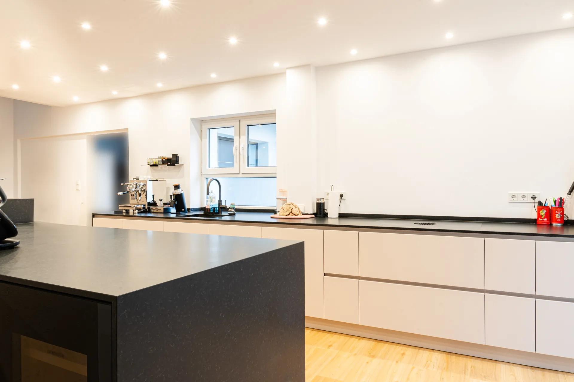 Grifflose Designküche mit Insel – Naturstein mit Häcker und Bora