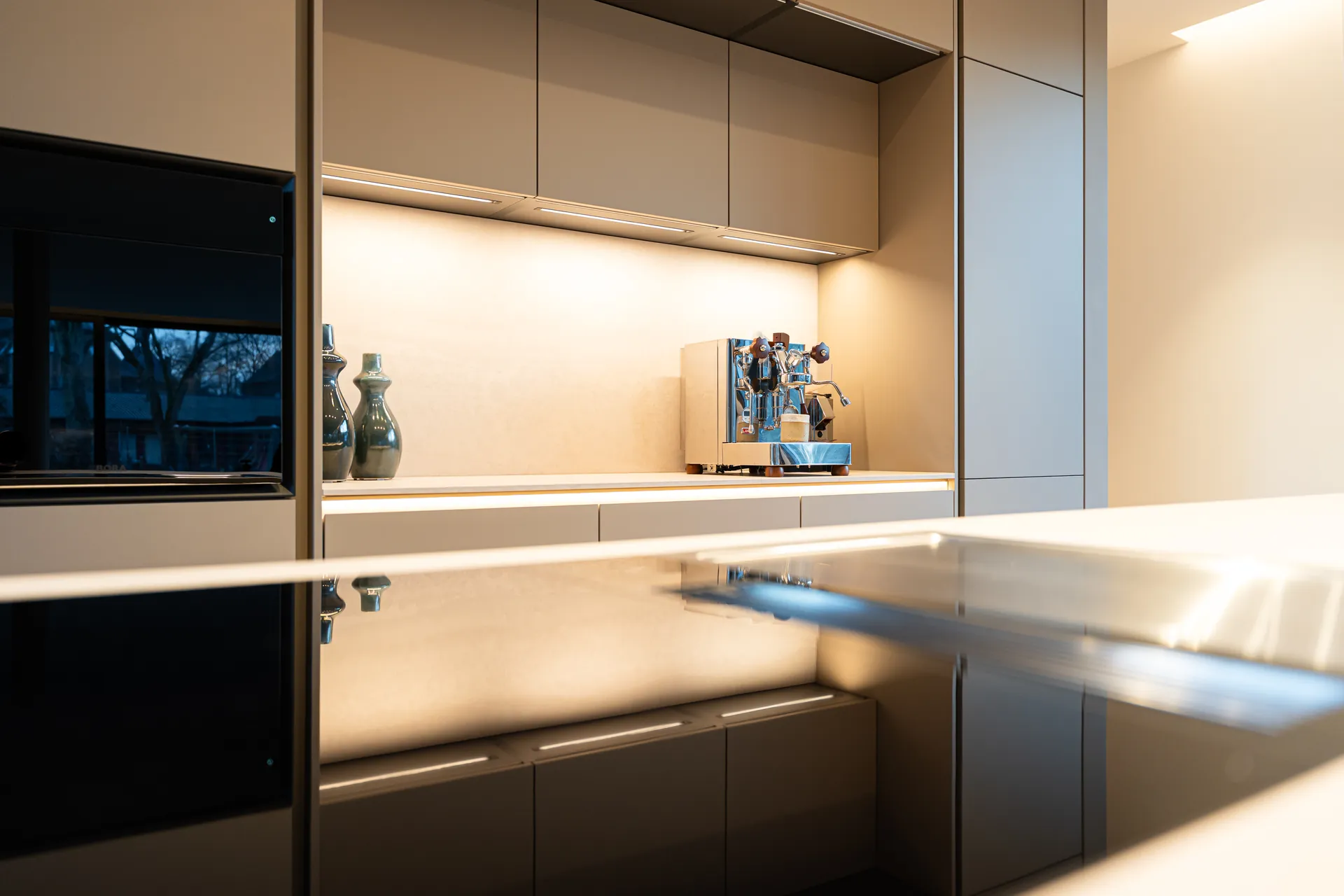 Grifflose Designküche mit Insel – Einzeilige Wohnküche mit Keramik