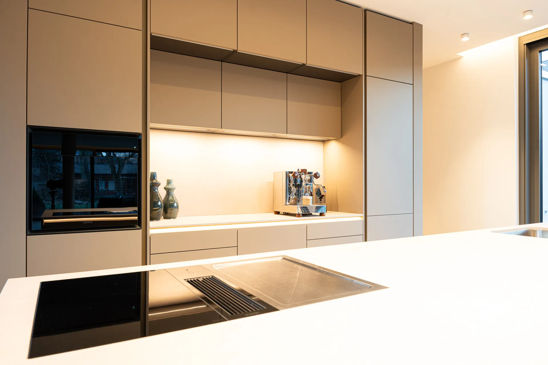 Grifflose Designküche mit Insel – Einzeilige Wohnküche mit Keramik