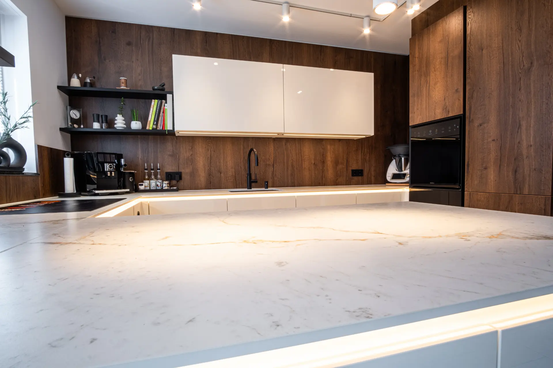 Grifflose Designküche in U-Form – Keramik und Nussbaum