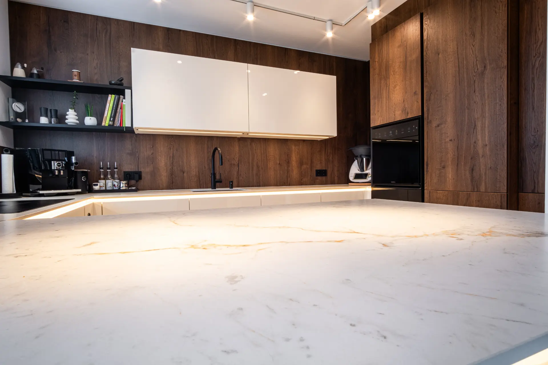 Grifflose Designküche in U-Form – Keramik und Nussbaum